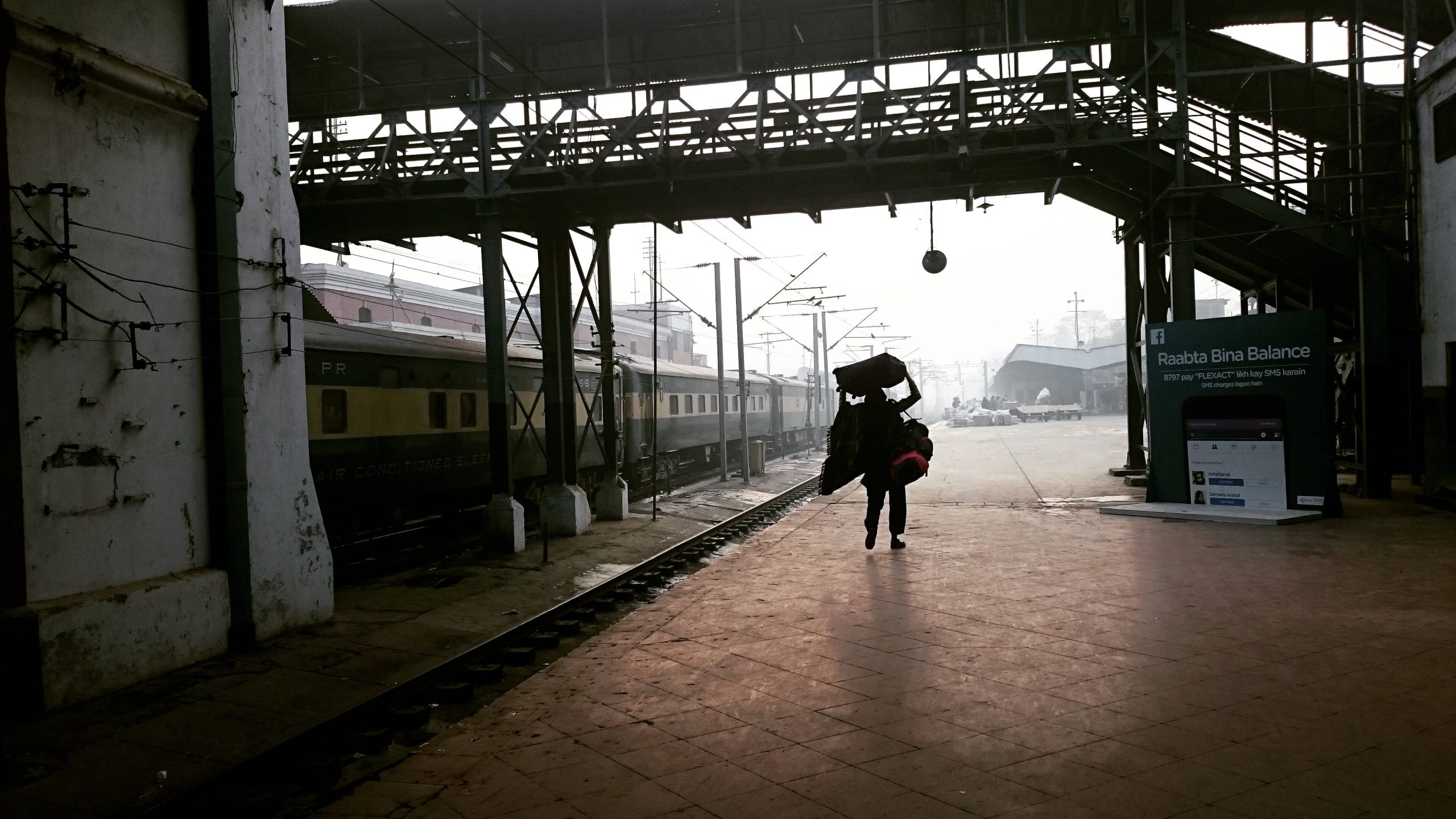 Coolie carrying luggage on Lahore railway station train terminal
